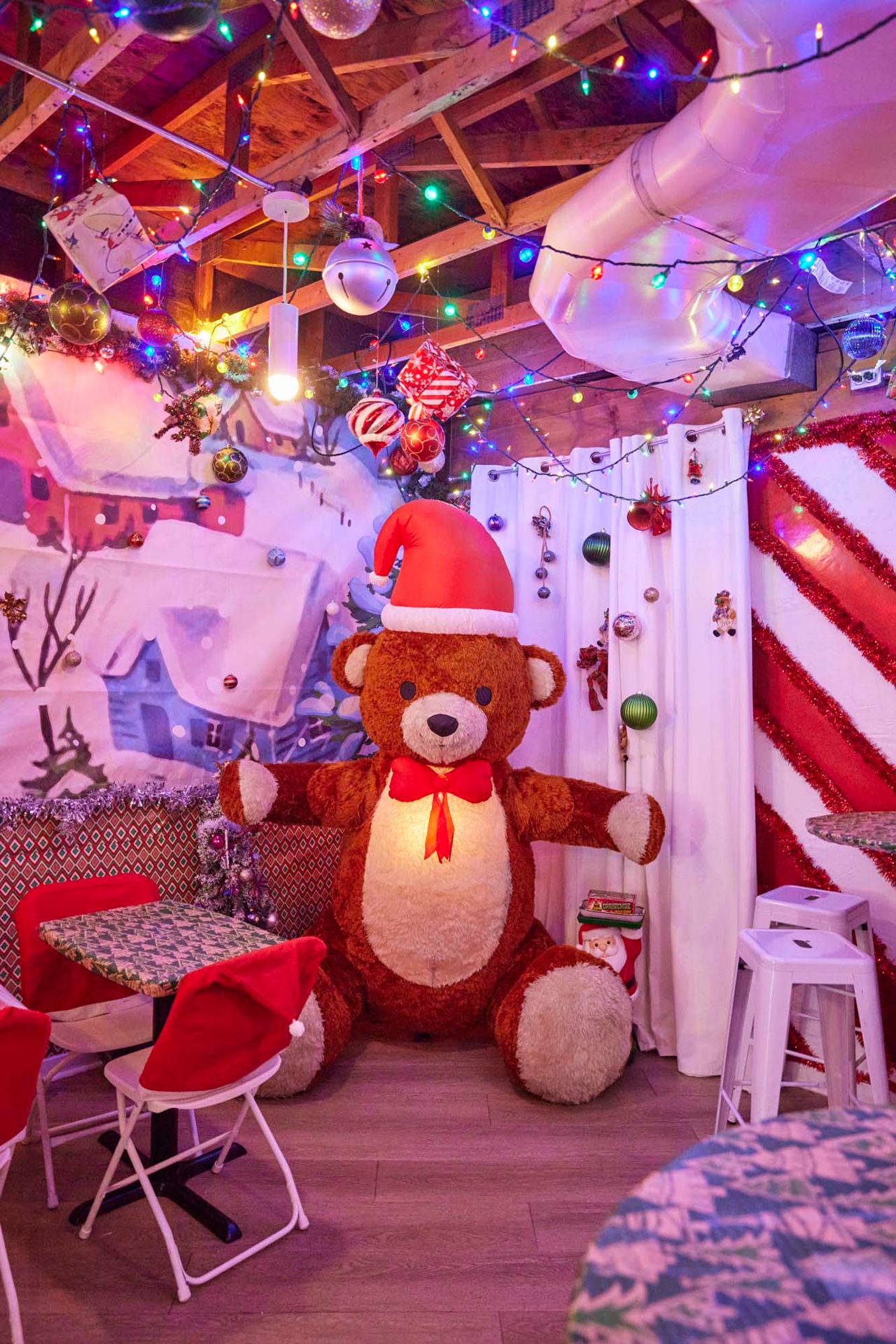 An animatronic teddy bear wearing a Santa hat