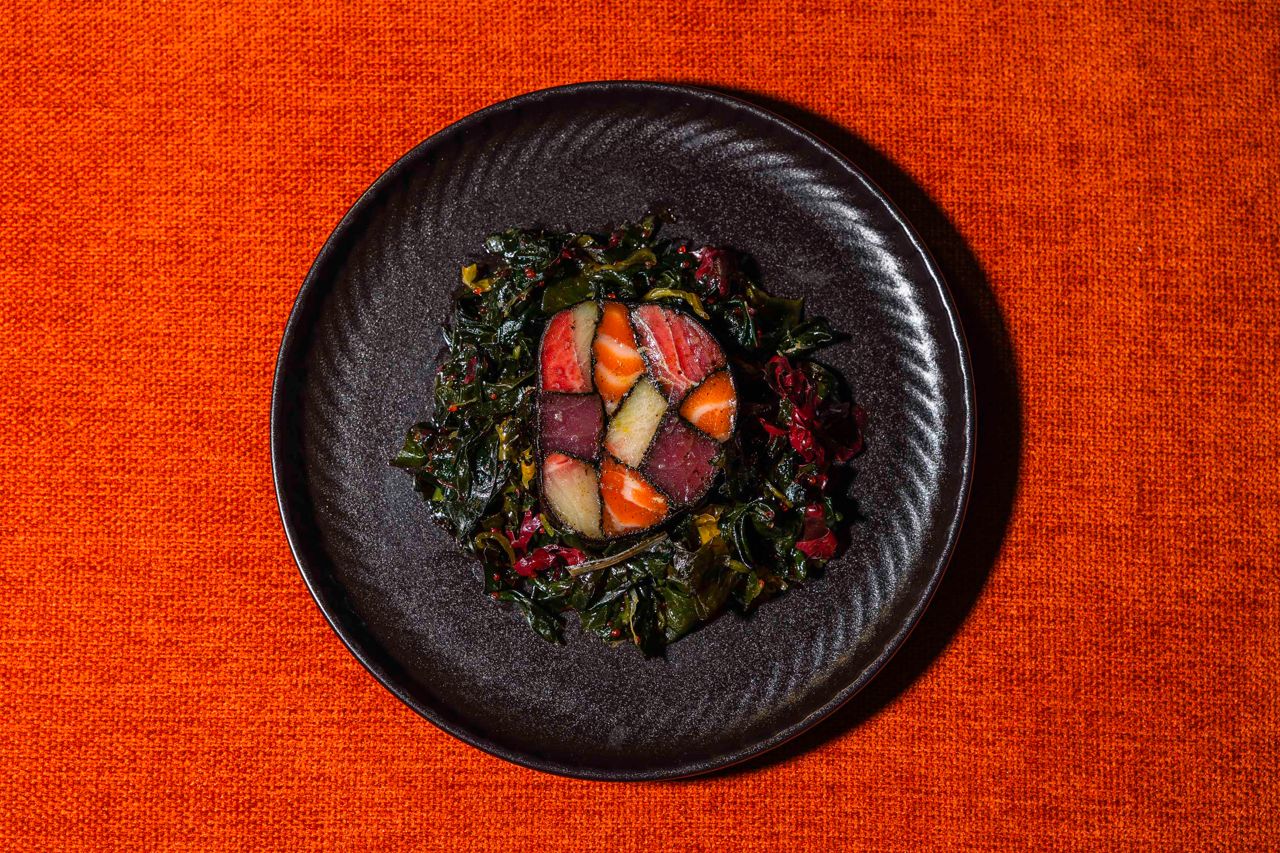 Hamachi, salmon and yellowfin loins are cured in herbs and spices, individually rolled in crushed seaweed, then rolled together and served with smoked ponzu on a bed of seaweed salad